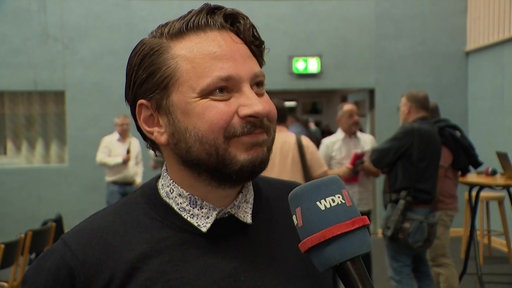 Robert Mazurek lächelt in die Kamera. 
