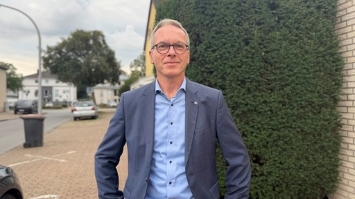 Dattelns Bürgermeister André Dora steht auf einem Gehweg und schaut in die Kamera.