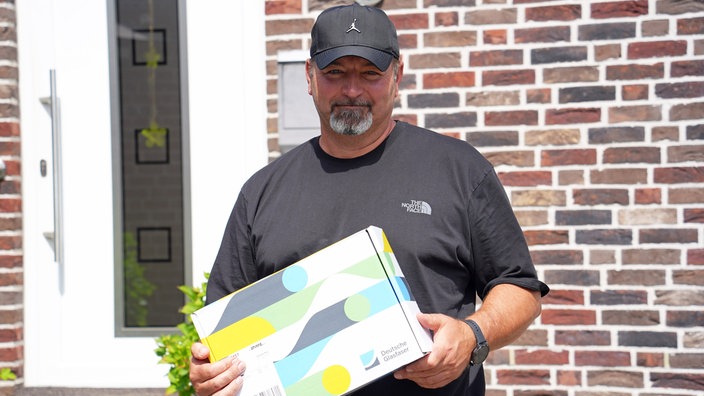 Michael Rodax hält eine Box in der Hand
