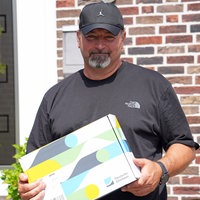 Michael Rodax hält eine Box in der Hand