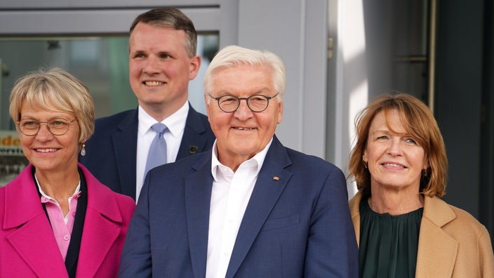 Vier personen blicken in die Kamera. 