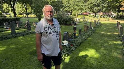 Rolf Klein steht am Grab seiner verstorbenen Frau.