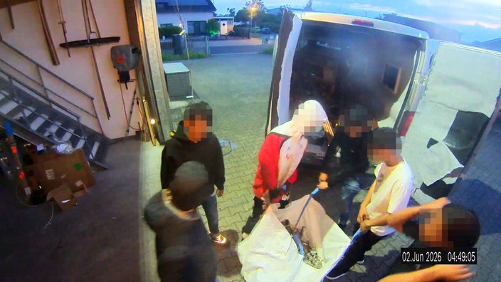 Eine Überwachungskamera zeigt Täter am frühen Morgen, wie sie mit einem Sack Beute abtransportieren