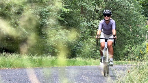 Eine Frau fährt auf einem Rennrad. 