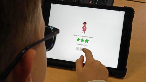 Ein Schüler blickt auf ein Tablet