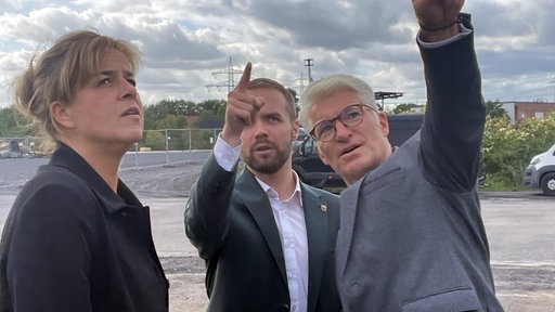 NRW-Ministerin Mona Neubaur besucht die Baustelle mit dem Waltroper Bürgermeister Marcel Mittelbach und Trianel-Chef Sven Becker. Die drei schauen nach oben und zeigen auf etwas. 