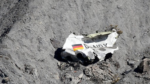 Ein Teil des Wracks liegt an einem steinigen Abhang 