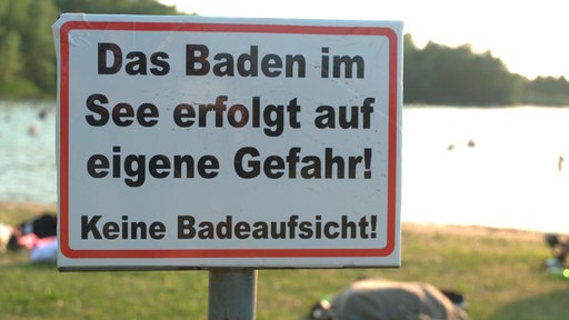 Das Bild zeigt ein Warnschild für Badegäste.
