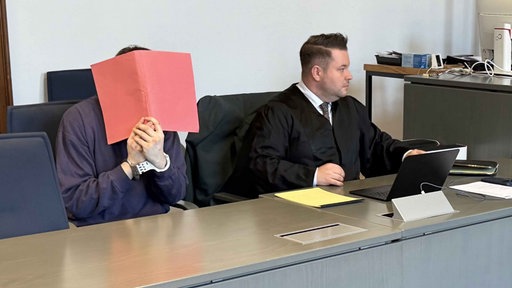 Der Angeklagte sitzt auf der Anklagebank neben seinem Anwalt