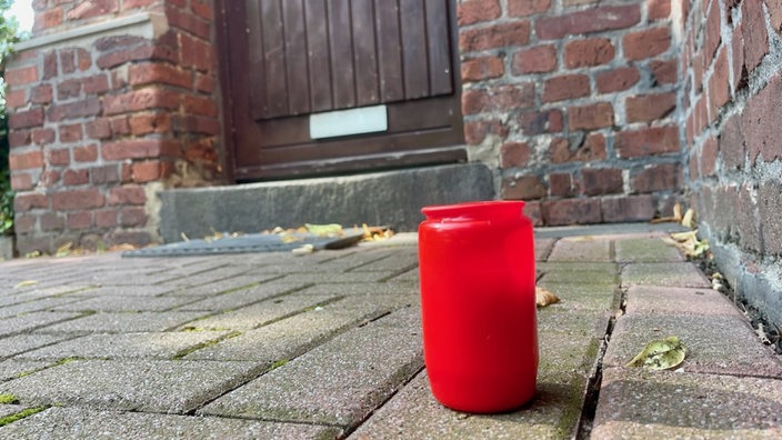 Eine Grabkerze steht vor dem Haus in Duisburg-Marxloh, in dem das Opfer gefunden wurde.
