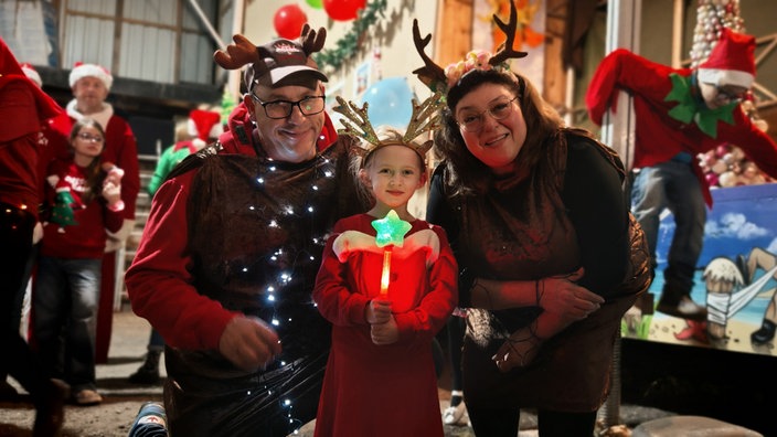 Dreiköpfige Familie in weihnachtlichem Elch-Kostüm