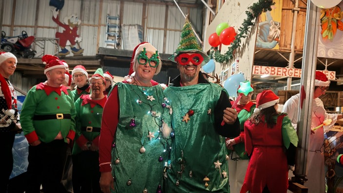 Mann und Frau in Weihnachtskostüm-Duo als Weihnachtsbaum