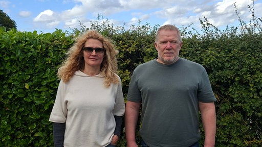 Frau und Mann mittleren Alters schauen in die Kamera