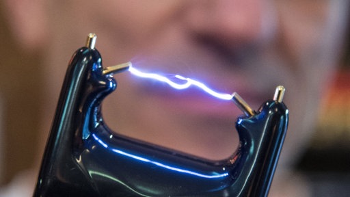 Ein Mann hält einen Elektroschocker in der Hand