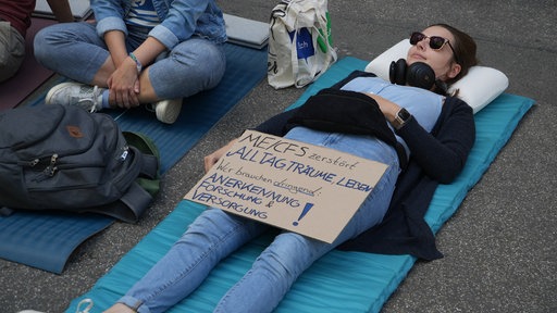 Eine Demonstrantin liegt auf dem Boden