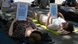 Zwei Demonstrantinnen liegen auf dem Boden