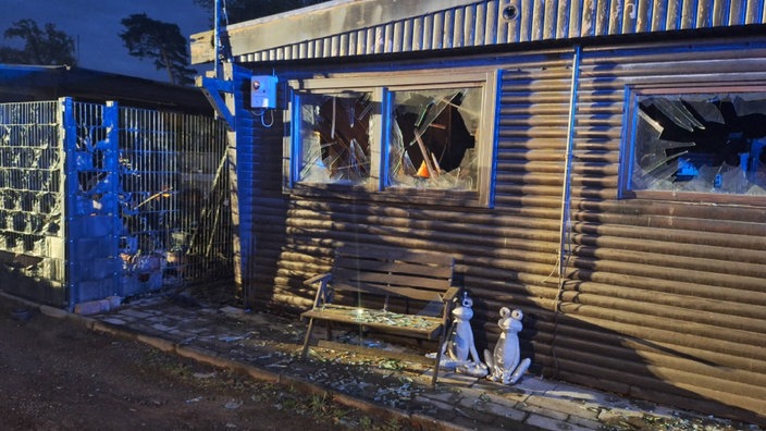 Die Fensterscheiben an einem kleinen Ferienhaus sind nach dem Brand auf dem Campingplatz zerborsten
