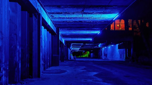 Blau beleuchteter Gang im Landschaftspark Nord bei Nacht.