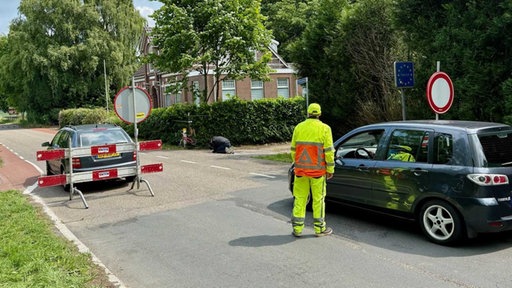 Eine Person kontrolliert einen Autofahrer an der niederländischen Grenze