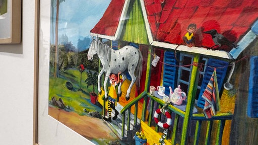 Ein Bilderrahmen zeigt Pippi Langstrump die ihr Pferd hochhebt.