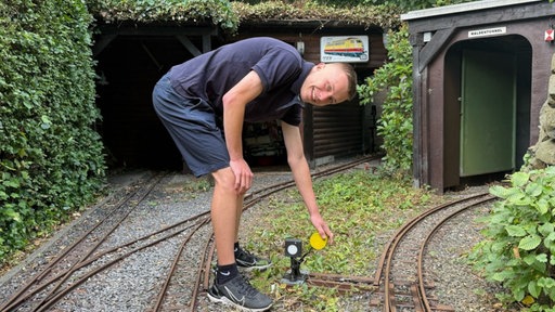 Ein Mann stellt eine Mini-Weiche um 