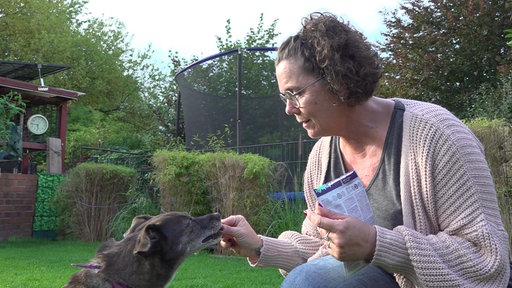 Yvonne Kamp gibt Ciri im Garten ein Leckerli