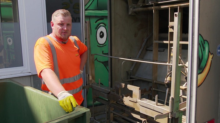 Das Bild zeigt Maurice Ihlo, der vor der Mülltonnen-Waschanlage steht.