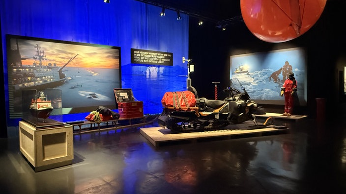 Blick in die Ausstellung Polar Experience, dort stehen ein Schneemobil und andere arktische Expeditionsgerätschaften