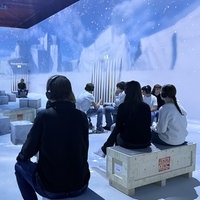 Junge Menschen sitzen in einem Raum, der wie eine arktische Landschaft gestaltet ist