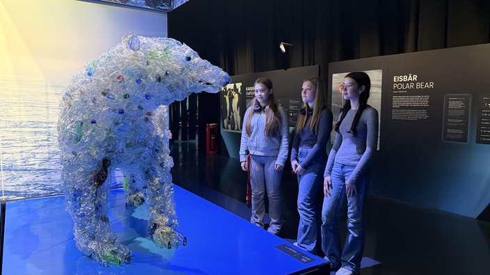 Drei Schülerinnen betrachten eine Eisbärstatue in der Ausstellung POLAR EXPERIENCE in Oberhausen