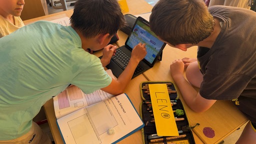 Kinder beugen sich über ihre Tablets