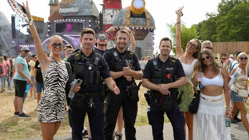 Vier Besucher und drei Polizisten