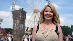 Eine Frau und im Hintergrund ist ein Riesenrad zu sehen 