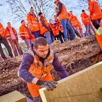 Die Bauarbeiter setzen die Steinwolle in die Grube an der Baustelle in der Alleestraße
