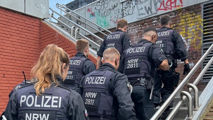 Eine uniformierte Gruppe von Polizeibeamten geht eine Treppe hoch.