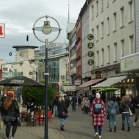 Passanten laufen in der Nähe vom Dortmunder Hansaplatz an Geschäften vorbei