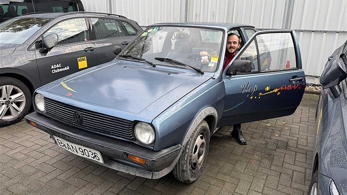 Einjunger Mann sitzt in einen alten VW Polo