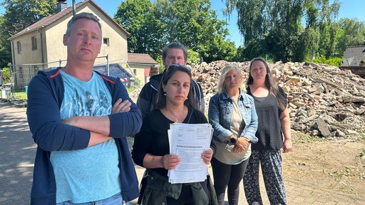 Anwohner der Essener Siedlung Litterode stehen vor den Trümmern ihrer Nachbarhäuser