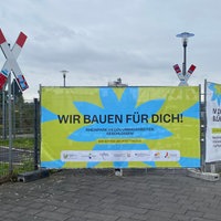 Ein großes, hellgünes Schild auf dem "Wir bauen für dich" steht