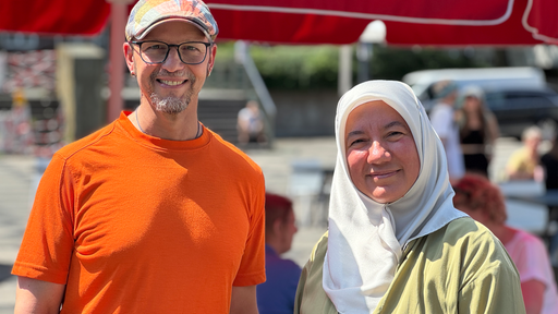Ein Mann und eine Frau stehen nebeneinander und lächeln beide freundlich
