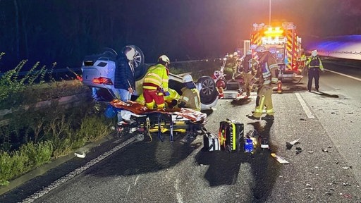 Einsatzkräfte der Feuerwehr bei der Rettung eines verunfallten Wagens. 