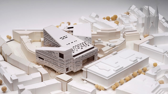 Ein weißes Stadtmodell mit einem markanten Bau in der Mitte