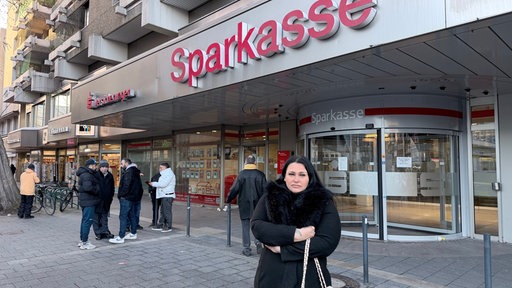 Kundin steht vor der Sparkassenfiliale in Gelsenkirchen