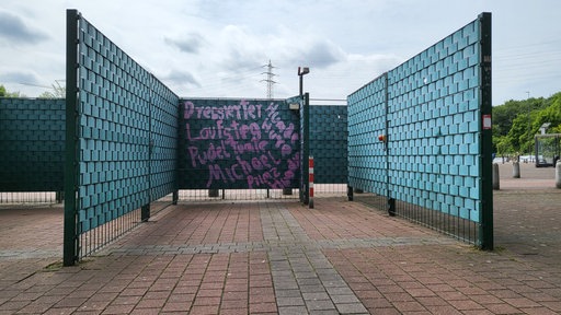 Grüner Zaun mit Graffiti