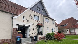 An der Fassade eines Hauses in der Herner Siedlung Teutoburgia hängen mehrere große Kunstspinnen, außerdem ist ein großes künstliches Spinnennetz bis in den Vorgarten gespannt