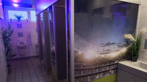 Toilette mit lila Lichtern und bemalten Wänden