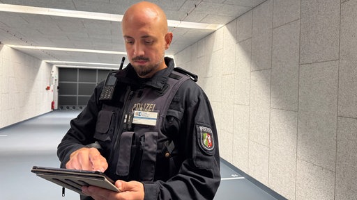 Niclas Keltjens steuert mit dem Tablet verschiedene Trainingsszenarien auf die Leinwand.