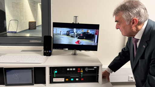 Innenminister Herbert Reul steht vor einem Monitor im neuen Trainingszentrum in Duisburg