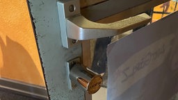 Es ist eine Tür mit Klinke und Drehknebel zusehen.