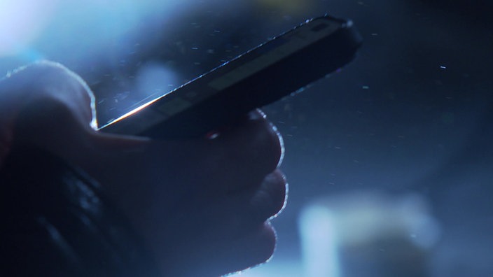 Hand tippt in ein Handy